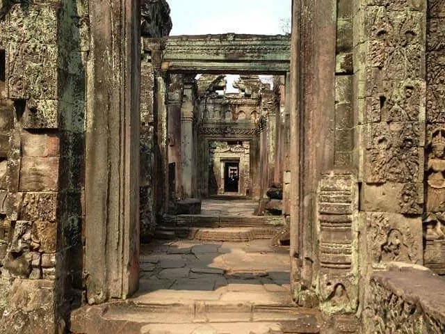 Stone passageway with carved walls inside the Preah Khan temple ruins.