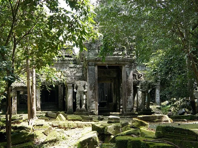 Overgrown stone ruins of Preah Khan temple surrounded by dense forest.