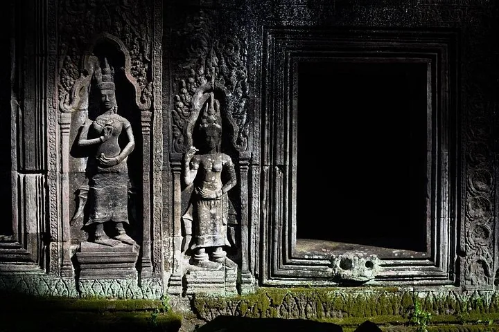 Stenen beeldhouwwerken van Apsara's op een muur bij de tempel Preah Khan.